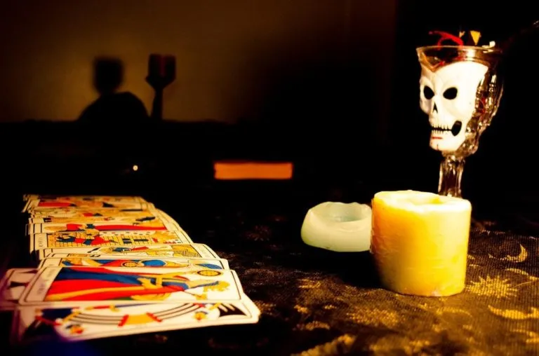 Mesa decorada para o Halloween com caveira, velas e cartas